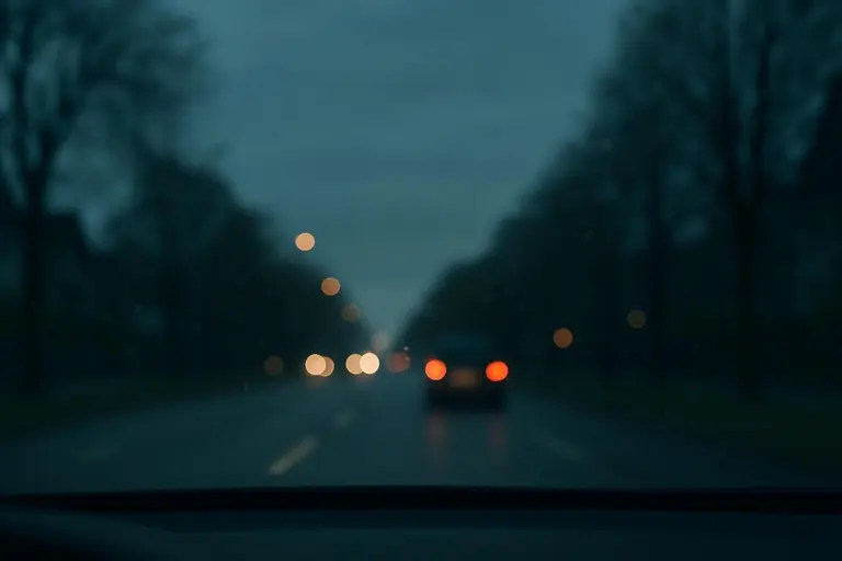 Naechtliche Strasse mit unscharfen Ruecklichtern in der Ferne